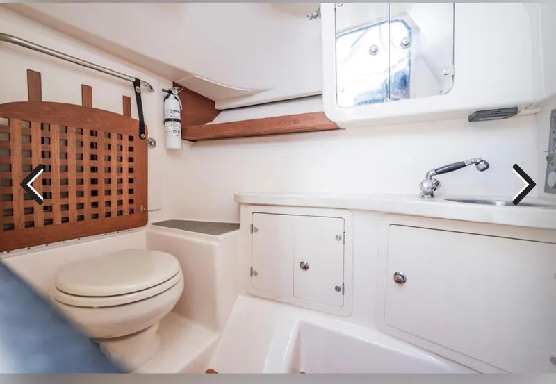 Slide: The Image of 2016 Grady-White Freedom 335 boat bathroom with toilet, sink, and storage cabinets. - 20