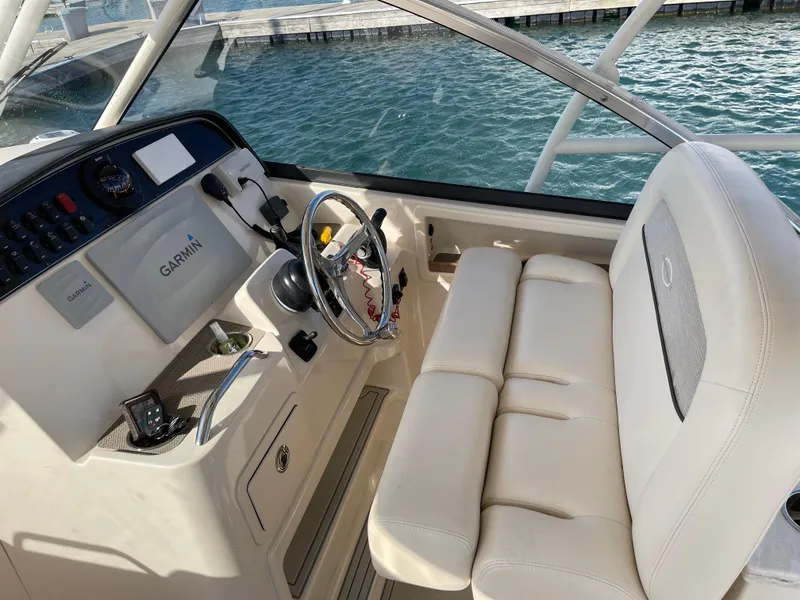 Slide: The Image of 2016 Grady-White Freedom 335 helm with Garmin system, white seating, and ocean backdrop. - 4