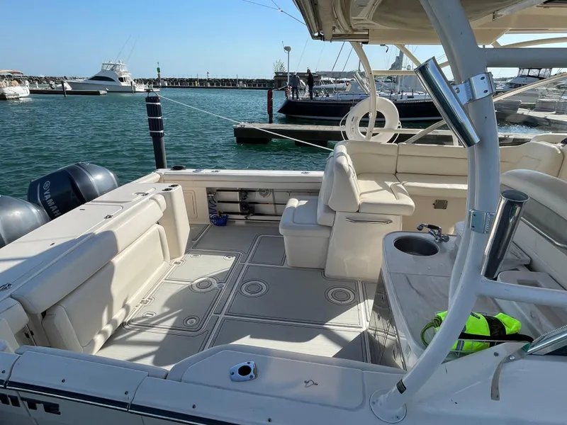 Slide: The Image of 2016 Grady-White Freedom 335 boat interior at marina, featuring spacious seating and twin engines. - 7