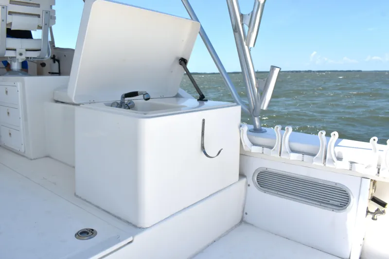 Slide: The Image of 2004 Judge 34 Express boat interior with open storage compartment and ocean view. - 11
