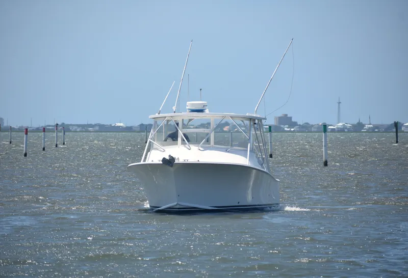 Slide: The Image of 2004 Judge 34 Express boat navigating through calm waters on a sunny day. - 2