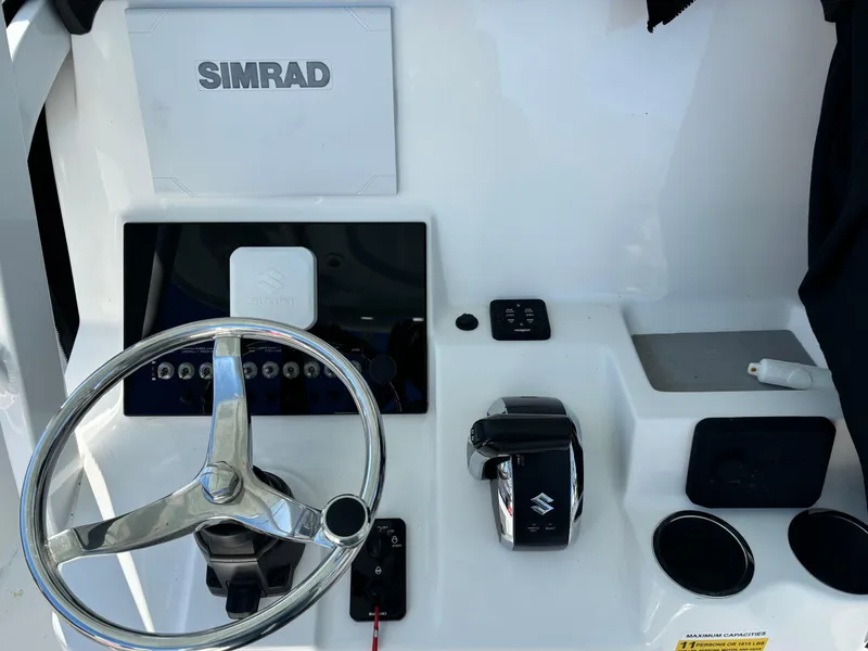 Slide: The Image of 2022 Sea Pro 239 Center Console dashboard with Simrad display and Suzuki controls. - 7