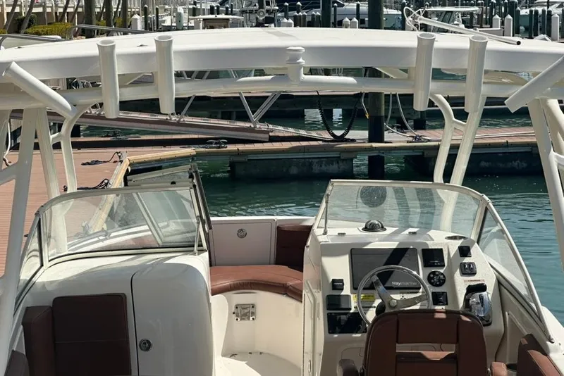 Slide: The Image of 2019 Century 24 Resorter boat interior with steering console and seating at marina. - 28