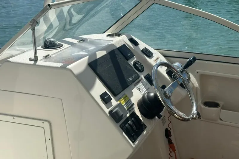 Slide: The Image of Cockpit of 2019 Century 24 Resorter boat with steering wheel and control panel. - 29