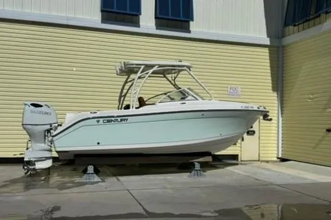 Slide: The Image of 2019 Century 24 Resorter boat on stands, parked outside a yellow building. - 38