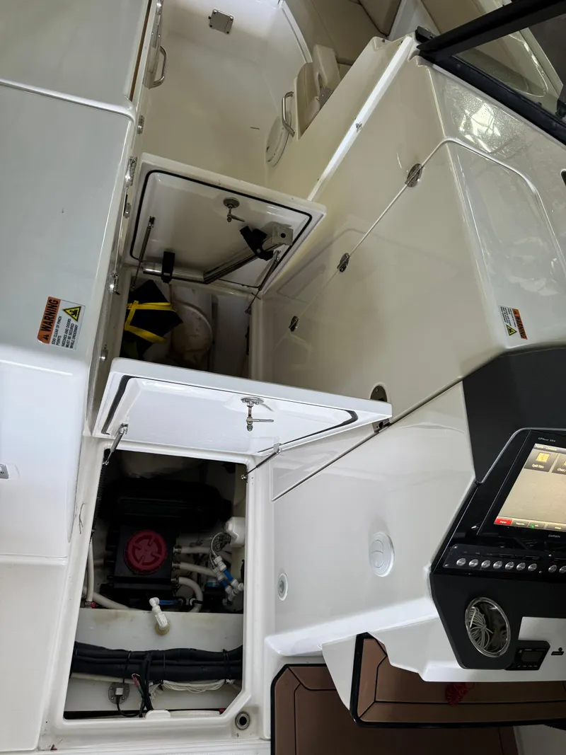 Slide: The Image of Interior view of a 2019 Everglades 340 Dual Console boat, showcasing storage compartments. - 12