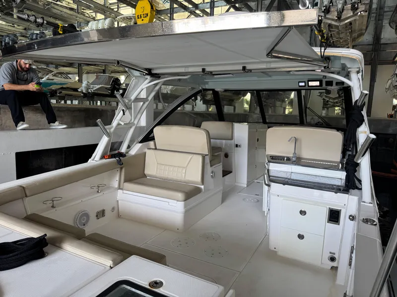 Slide: The Image of 2019 Everglades 340 Dual Console boat interior with seating and kitchenette in a marina. - 22