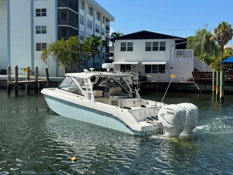 Slide: The Image of 2019 Everglades 340 Dual Console boat cruising near waterfront homes. - 26