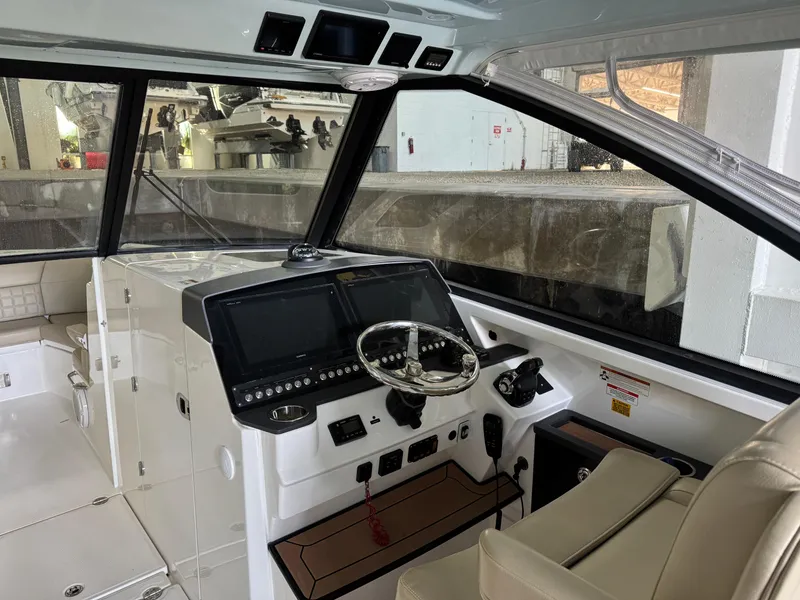 Slide: The Image of 2019 Everglades 340 Dual Console boat interior with modern dashboard and steering wheel. - 3