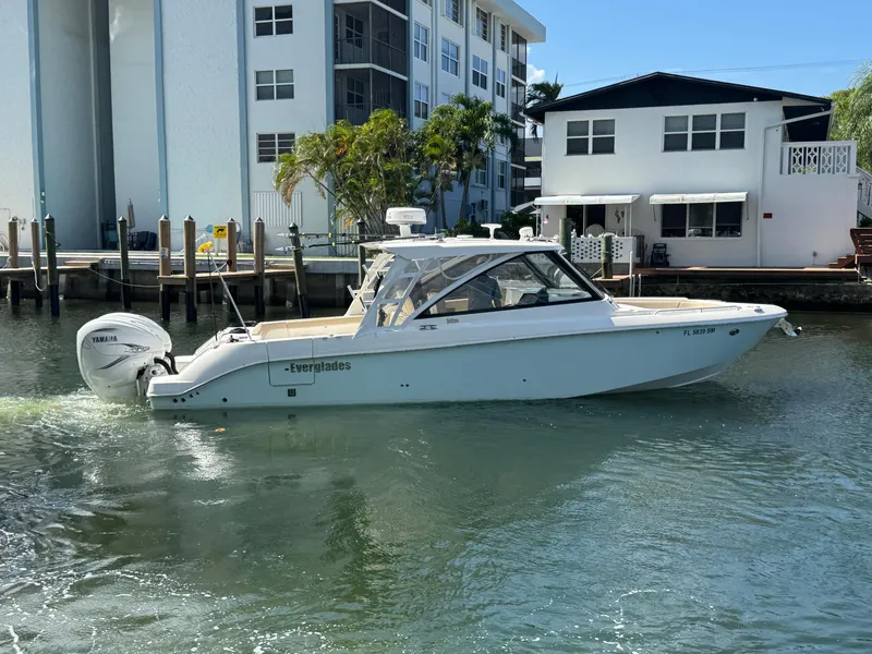 Slide: The Image of 2019 Everglades 340 Dual Console boat on water near residential buildings. - 30
