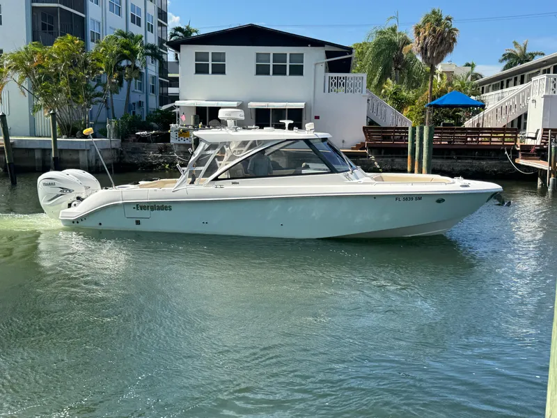 Slide: The Image of 2019 Everglades 340 Dual Console boat on water near residential area. - 31