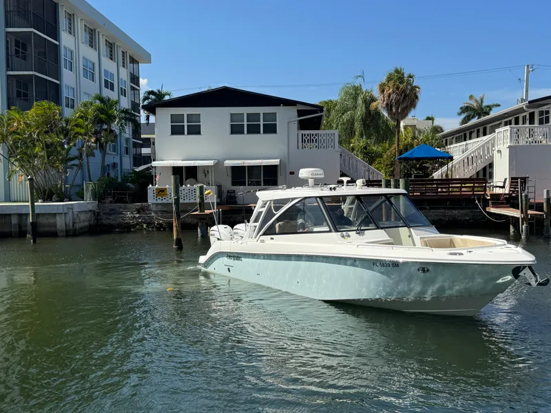 Slide: The Image of 2019 Everglades 340 Dual Console boat on water near residential buildings. - 32
