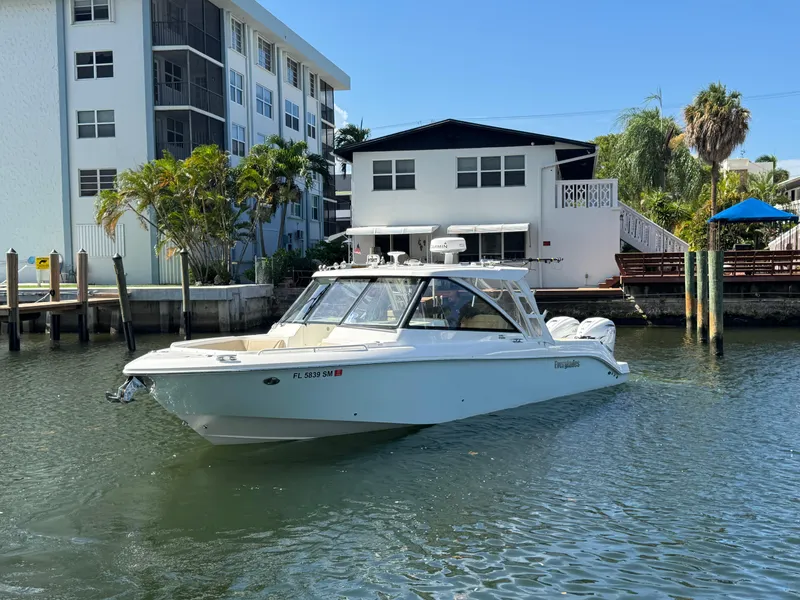 Slide: The Image of 2019 Everglades 340 Dual Console boat docked near waterfront buildings. - 35