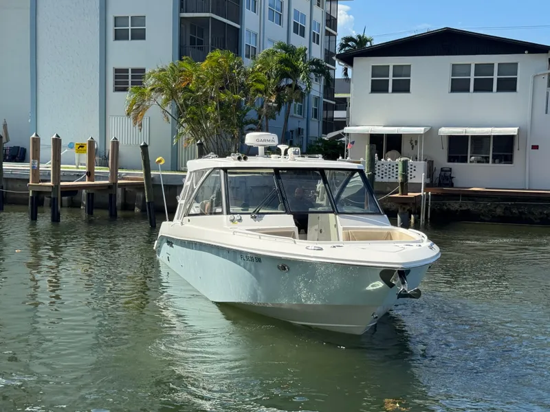 Slide: The Image of 2019 Everglades 340 Dual Console boat docked near waterfront homes. - 37
