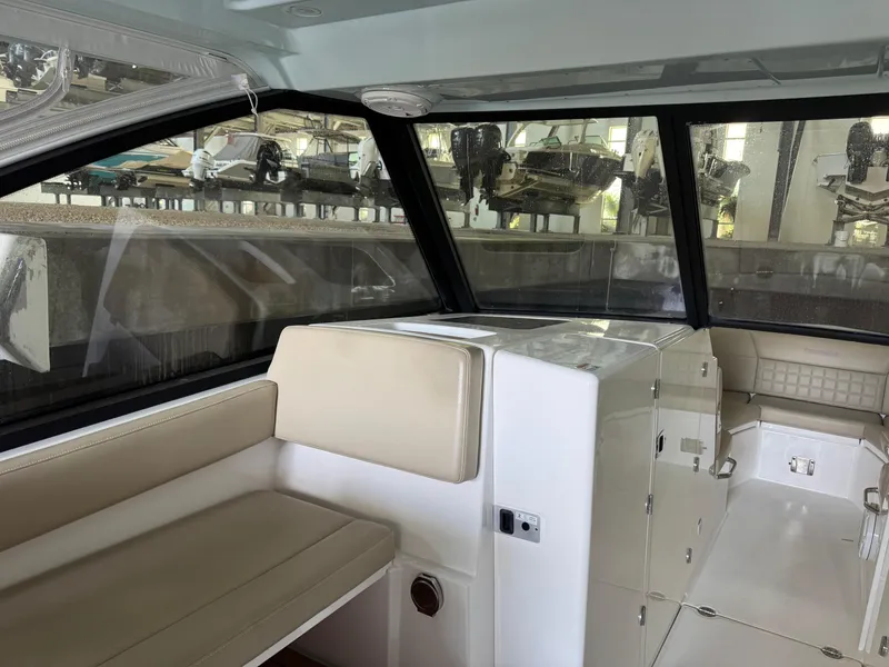 Slide: The Image of Interior of a 2019 Everglades 340 Dual Console boat with beige seating and large windows. - 4