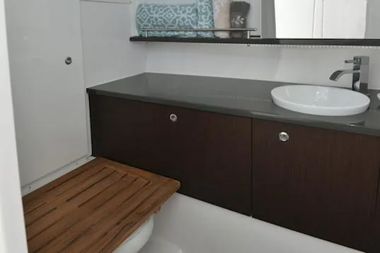 Slide: The Image of Manufacturer Provided Image: 2019 Everglades 340 Dual Console bathroom with modern sink and wooden accents. - 44