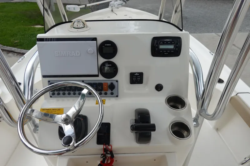 Slide: The Image of 2015 Key West 230 Bay Reef boat dashboard with steering wheel and controls. - 16