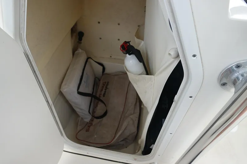 Slide: The Image of Storage compartment of 2015 Key West 230 Bay Reef boat with safety gear and fire extinguisher. - 28