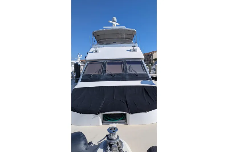 Slide: The Image of 1992 Viking 65 Motor Yacht with covered windows, docked under clear blue sky. - 2