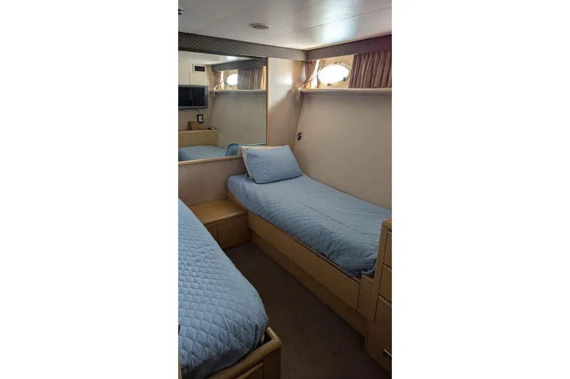 Slide: The Image of 1992 Viking 65 Motor Yacht cabin with twin beds and blue bedding. - 7