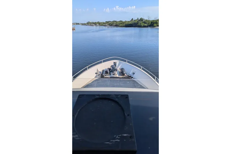 Slide: The Image of Bow view of 1992 Viking 65 Motor Yacht cruising on calm waters. - 9