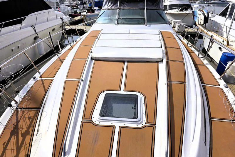 Slide: The Image of 1999 Sea Ray Sundancer 540 yacht deck with teak flooring, docked at a marina. - 31