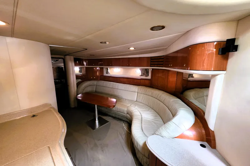 Slide: The Image of Luxurious interior of 1999 Sea Ray Sundancer 540 yacht with curved seating and wooden accents. - 4