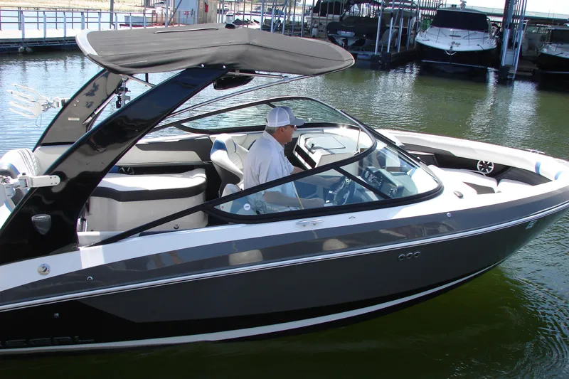 Slide: The Image of 2017 Regal 2300 RX Surf boat with canopy, docked in a marina. - 10