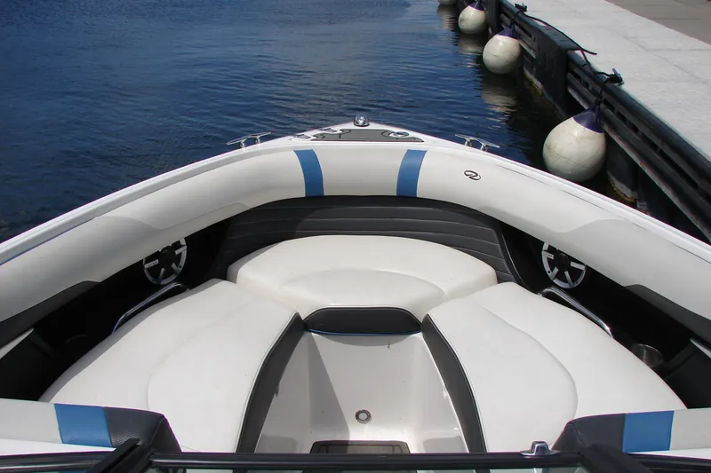 Slide: The Image of Bow seating area of a 2017 Regal 2300 RX Surf boat docked by the water. - 24