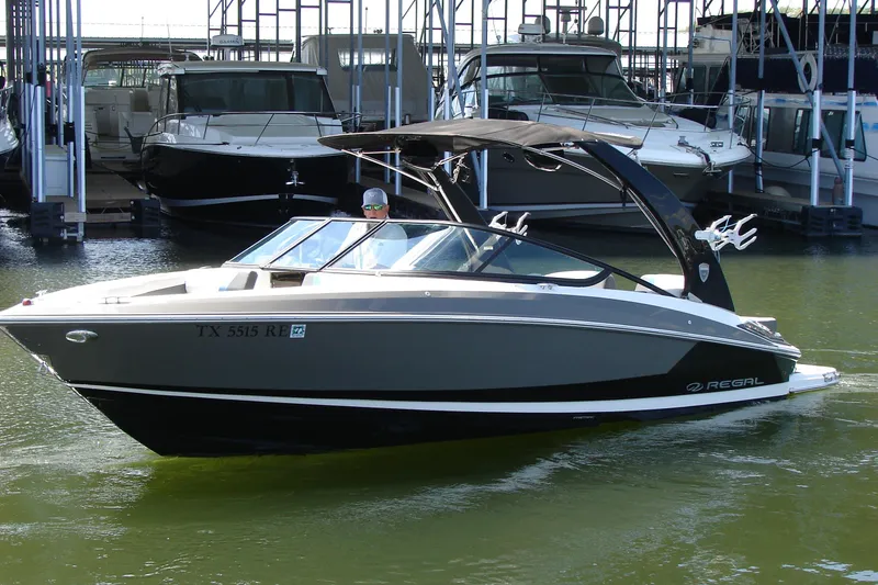 Slide: The Image of 2017 Regal 2300 RX Surf boat docked in marina, featuring sleek design and black canopy. - 3