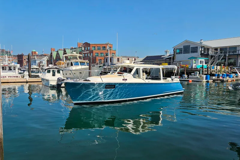 Slide: The Image of 2023 MJM 35 boat docked in a vibrant marina under clear blue skies. - 2