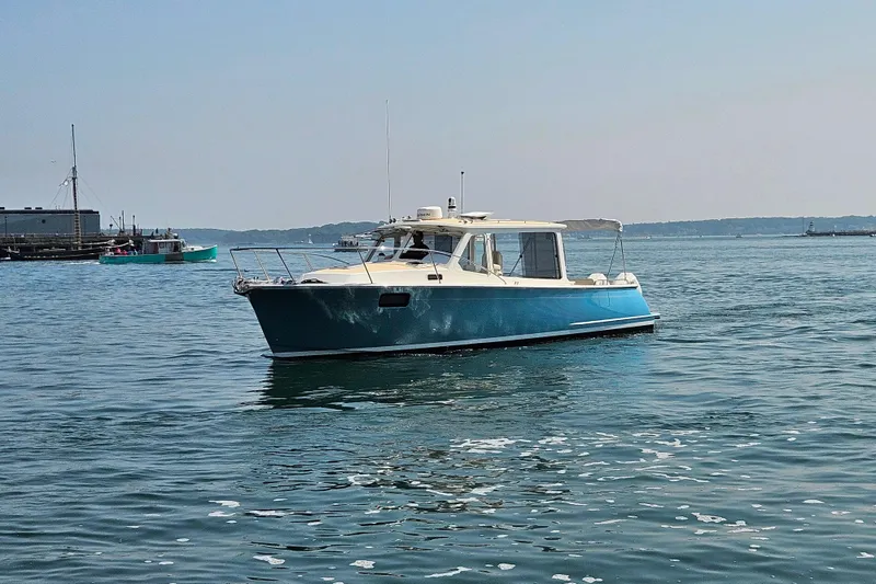 Slide: The Image of 2023 MJM 35 boat cruising on calm waters near a harbor. - 3