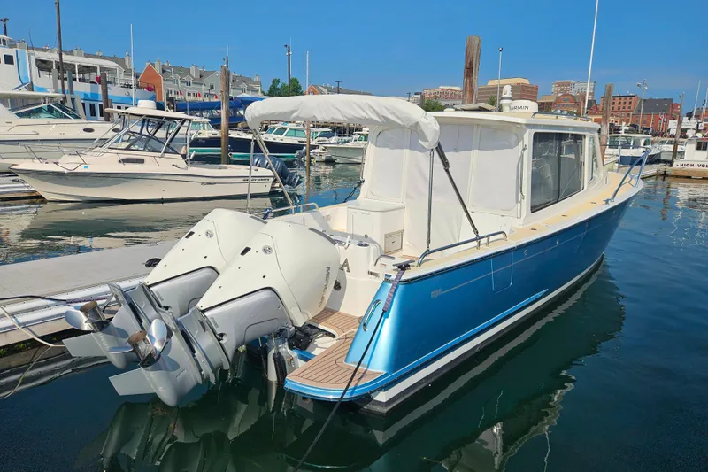 Slide: The Image of 2023 MJM 35 boat docked in marina with twin outboard engines. - 41