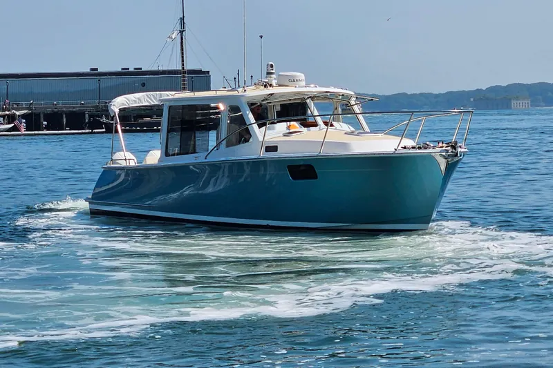 Slide: The Image of 2023 MJM 35 boat cruising on calm waters near a dock. - 6