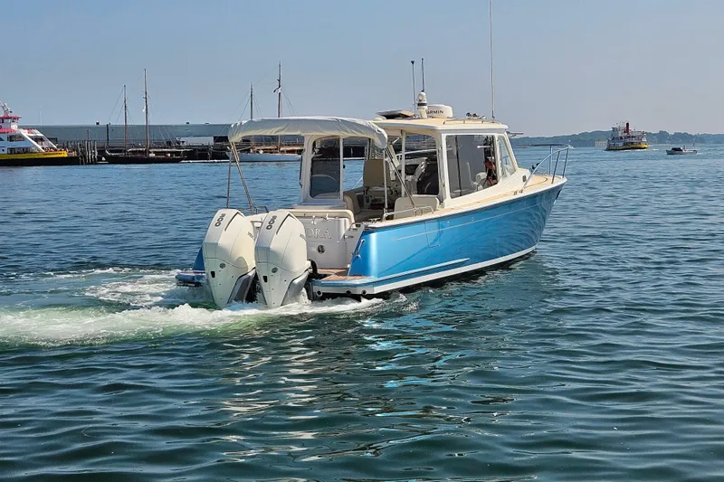 Slide: The Image of 2023 MJM 35 boat cruising on calm waters with twin outboard engines. - 8