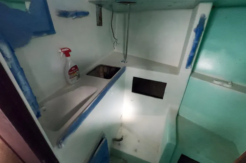 Slide: The Image of Interior of a 1980 Morgan 382 sailboat with cleaning supplies and sink. - 12