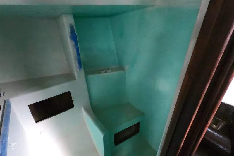 Slide: The Image of Interior of a 1980 Morgan 382 sailboat, featuring a compact, turquoise-painted cabin space. - 13