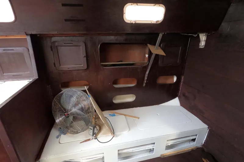 Slide: The Image of Interior of 1980 Morgan 382 sailboat with wooden paneling and a fan. - 15