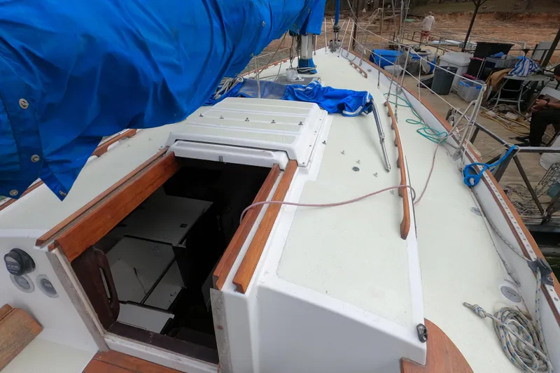 Slide: The Image of 1980 Morgan 382 sailboat deck with open hatch and blue sail cover. - 2