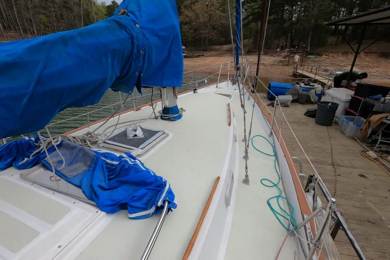 Slide: The Image of 1980 Morgan 382 sailboat docked, featuring blue sail cover and deck equipment. - 4