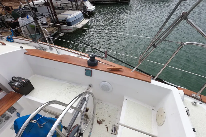 Slide: The Image of 1980 Morgan 382 sailboat cockpit with steering wheel, docked at marina. - 5