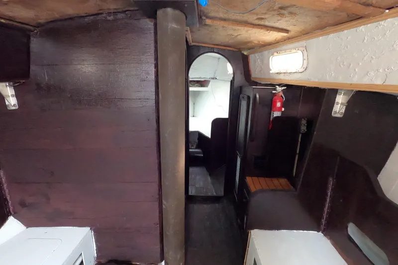 Slide: The Image of Interior of a 1980 Morgan 382 sailboat with wooden paneling and a fire extinguisher. - 8