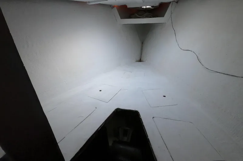 Slide: The Image of Interior view of a 1980 Morgan 382 sailboat cabin, featuring a clean, white-painted space. - 9