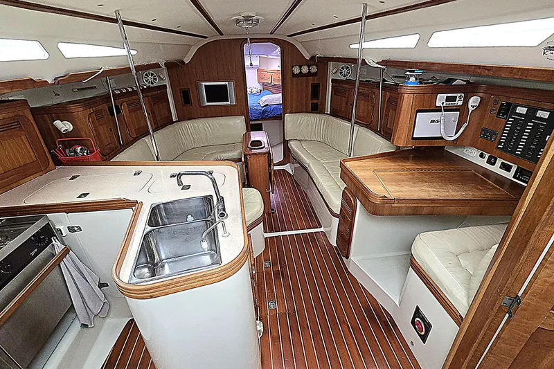 Slide: The Image of Luxurious 2004 C&C 121 yacht interior with wood finishes, kitchen, and seating area. - 2