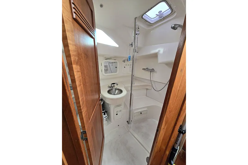 Slide: The Image of Compact yacht bathroom with shower, sink, and wooden door in a 2004 C&C 121 model. - 7
