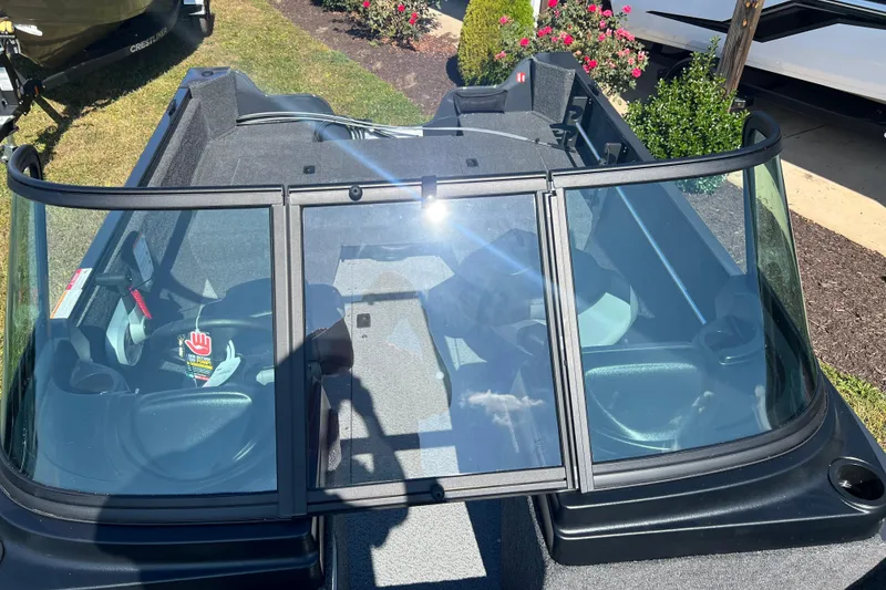 Slide: The Image of 2026 Crestliner 1650 Kodiak boat with windshield, parked on grass near flowers. - 10