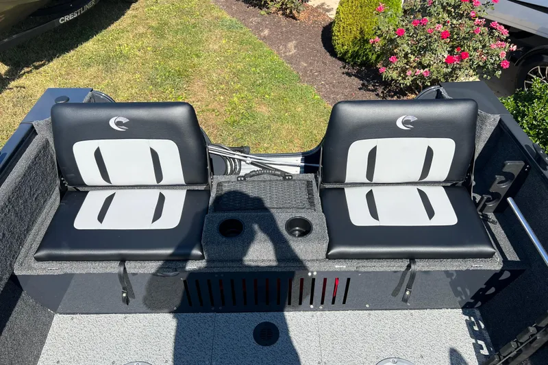 Slide: The Image of 2026 Crestliner 1650 Kodiak boat seats with cup holders, outdoor setting. - 16