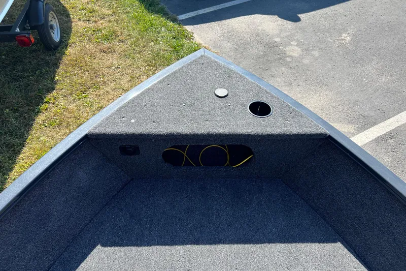 Slide: The Image of 2026 Crestliner 1650 Kodiak boat interior with carpeted deck and storage compartment. - 6