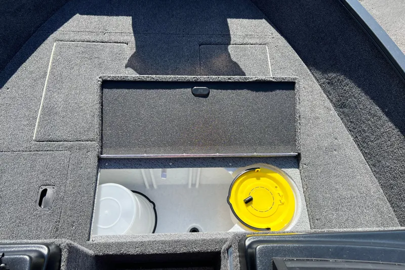 Slide: The Image of 2026 Crestliner 1650 Kodiak boat interior with storage compartment and yellow lid. - 9