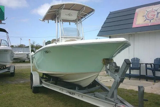 Slide: The Image of 2017 Key West 203 FS boat on trailer, parked outdoors near a building. - 2